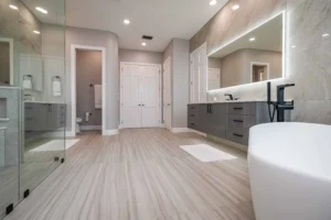 luxury spa style bathroom remodel by CMK construction; shower with glass door and rainfall showerhead, custom bathtub, new countertops, custom mirror with backlight.