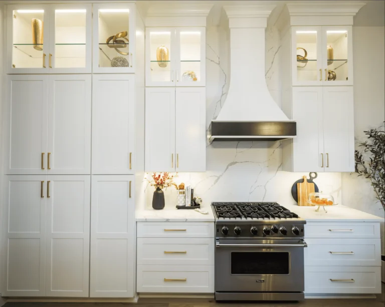 Luxury custom white kitchen with stainless steel gas stove, white cabinets and gold fixtures - remodel done by CMK construction