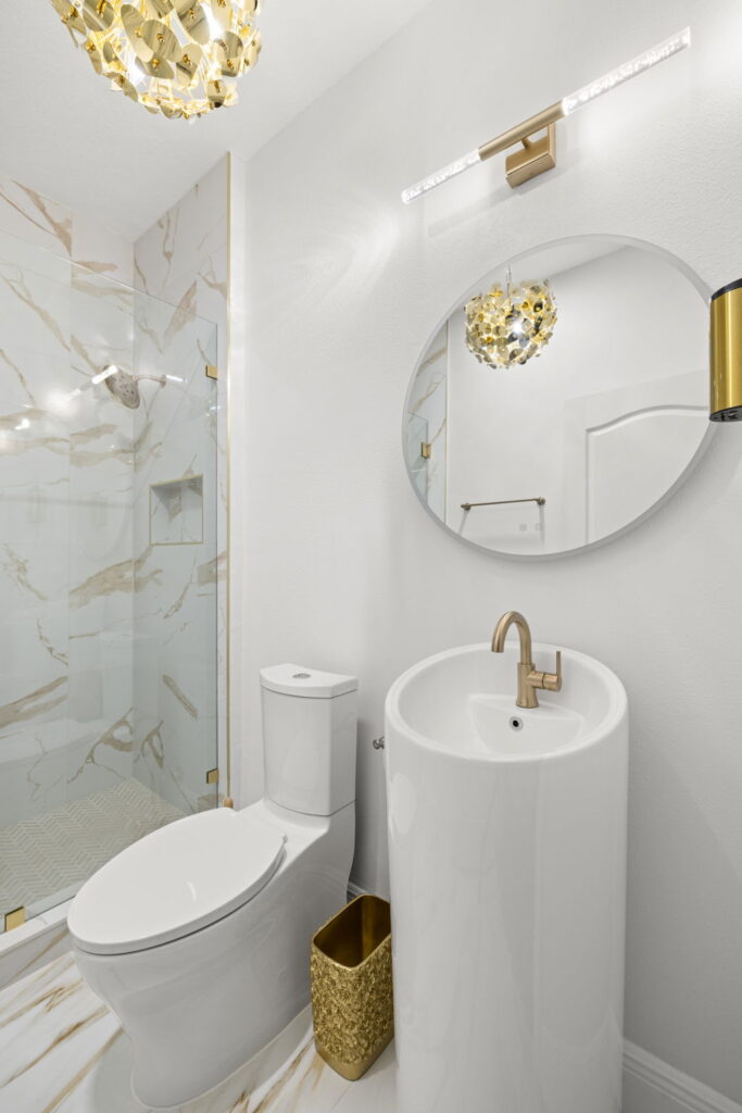 Modern bathroom with gold accents and marble shower in Sarasota, FL