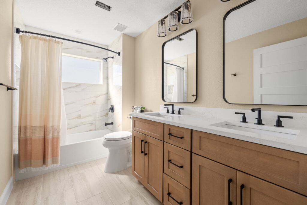 Modern bathroom with wooden vanity and marble tiles.