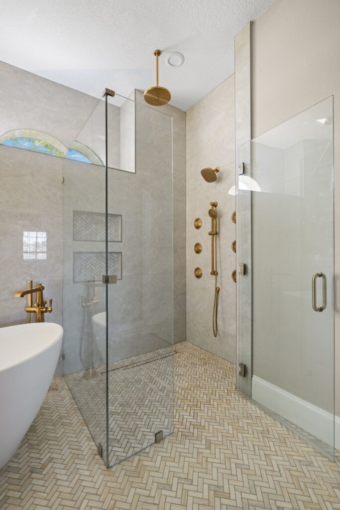 Modern bathroom with a glass shower and gold fixtures in Westchase, FL