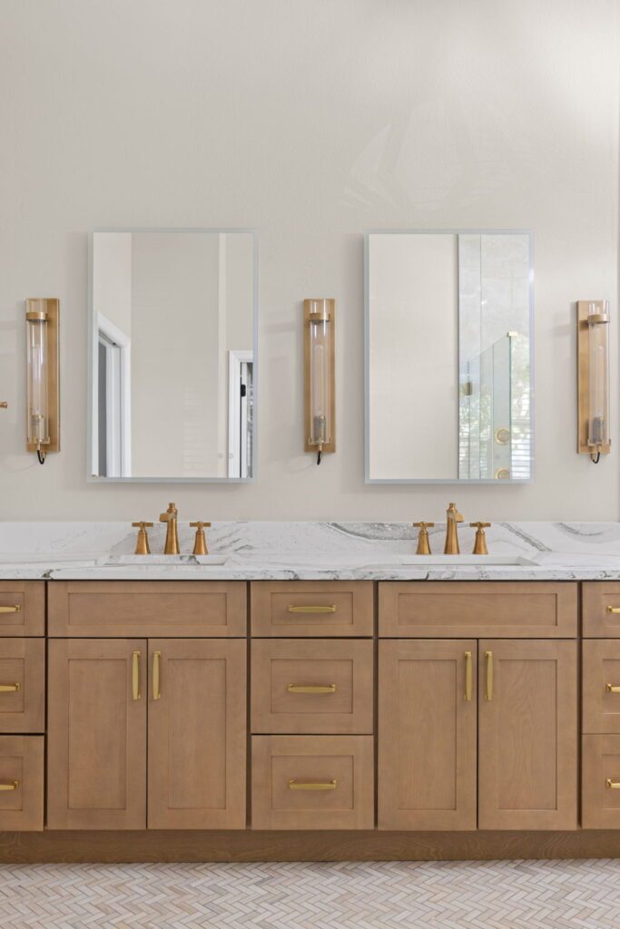 Modern bathroom with wooden cabinets and marble sinks.