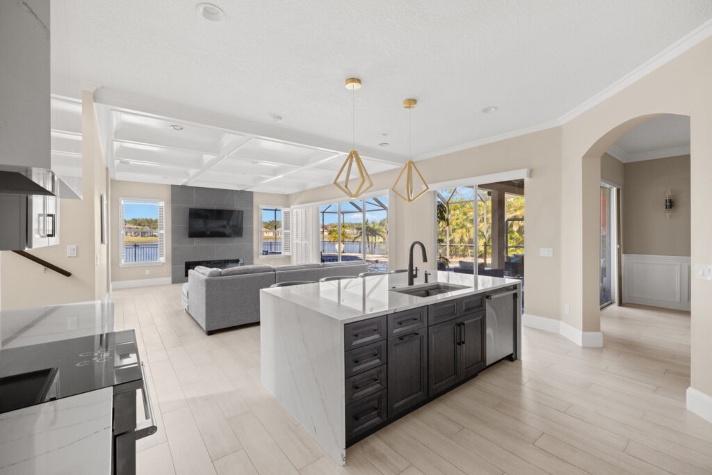 Modern kitchen and living room with large windows view.