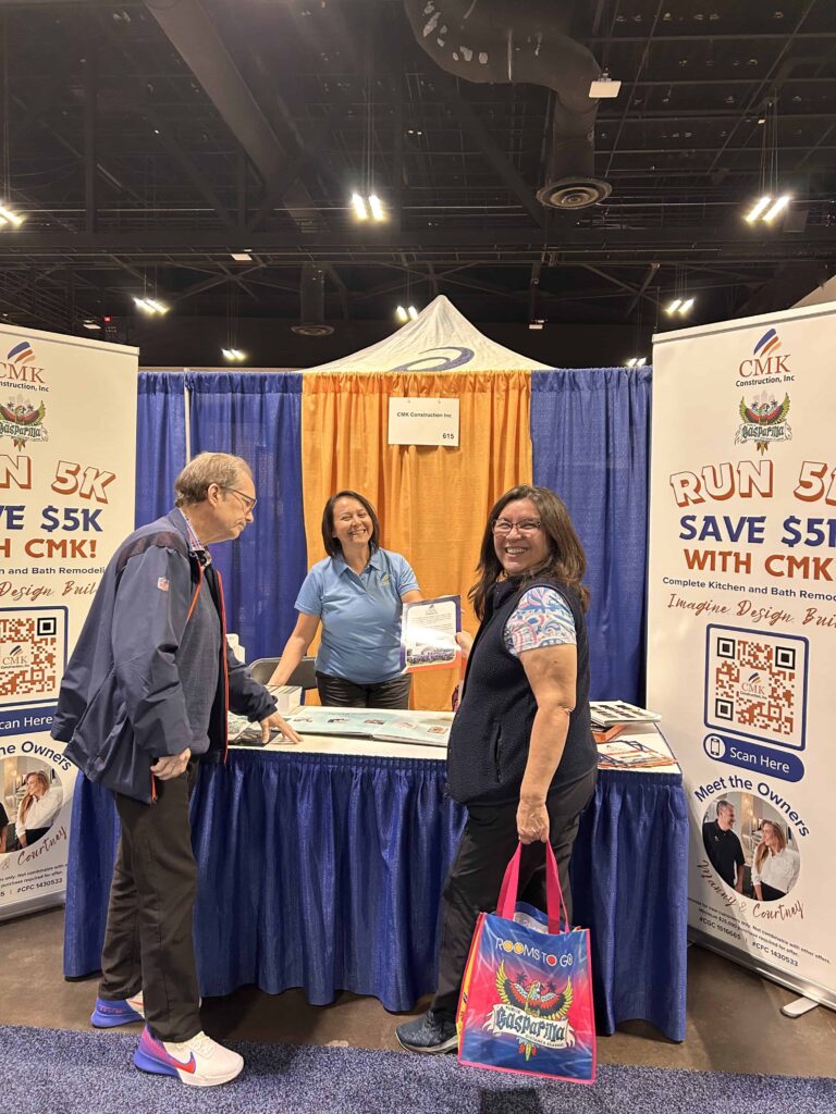 CMK Construction booth at trade show with visitors.