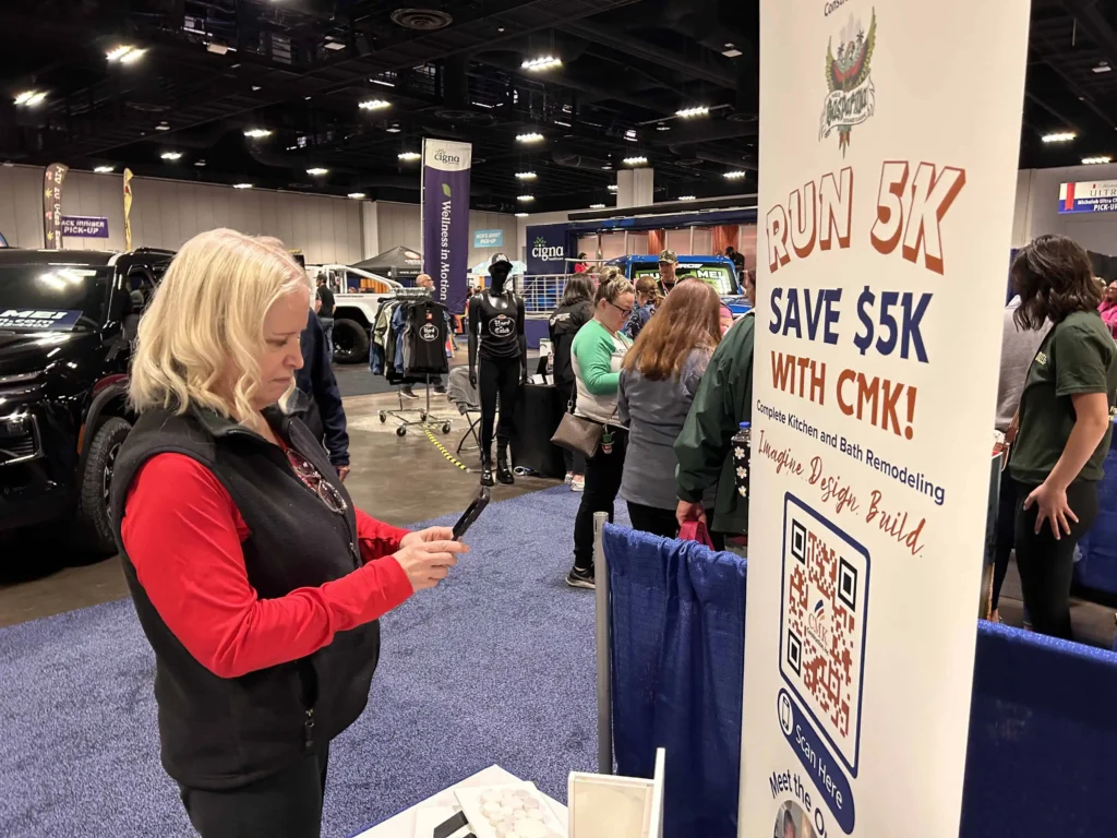 Woman at expo scanning for 5K run promotion.