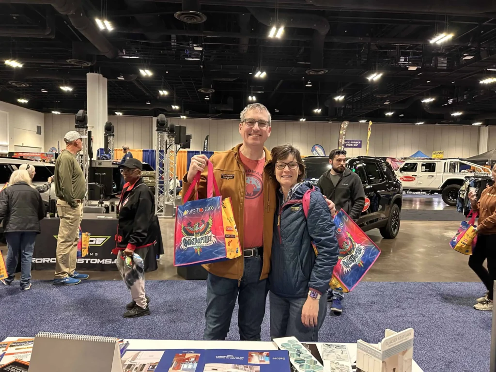 People at an indoor automotive trade show event.
