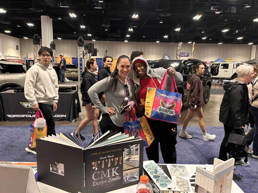 Car show visitors holding gift bags and brochures.
