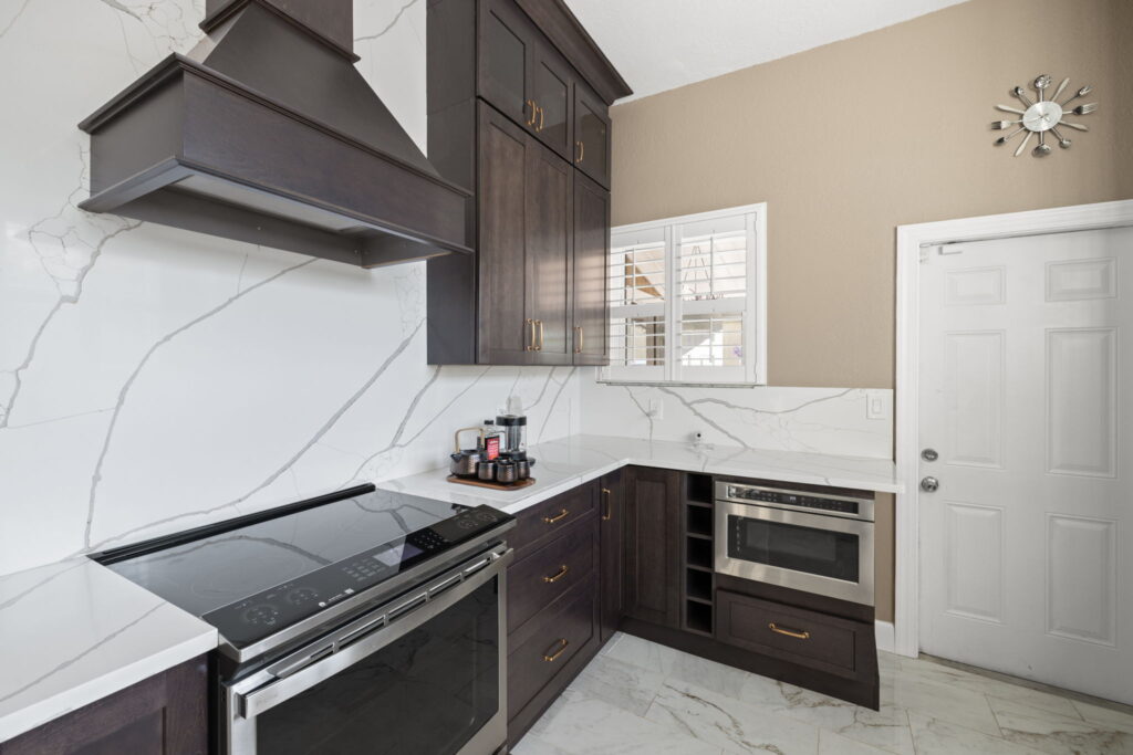 electric stove top with custom exhaust fan, marble countertops