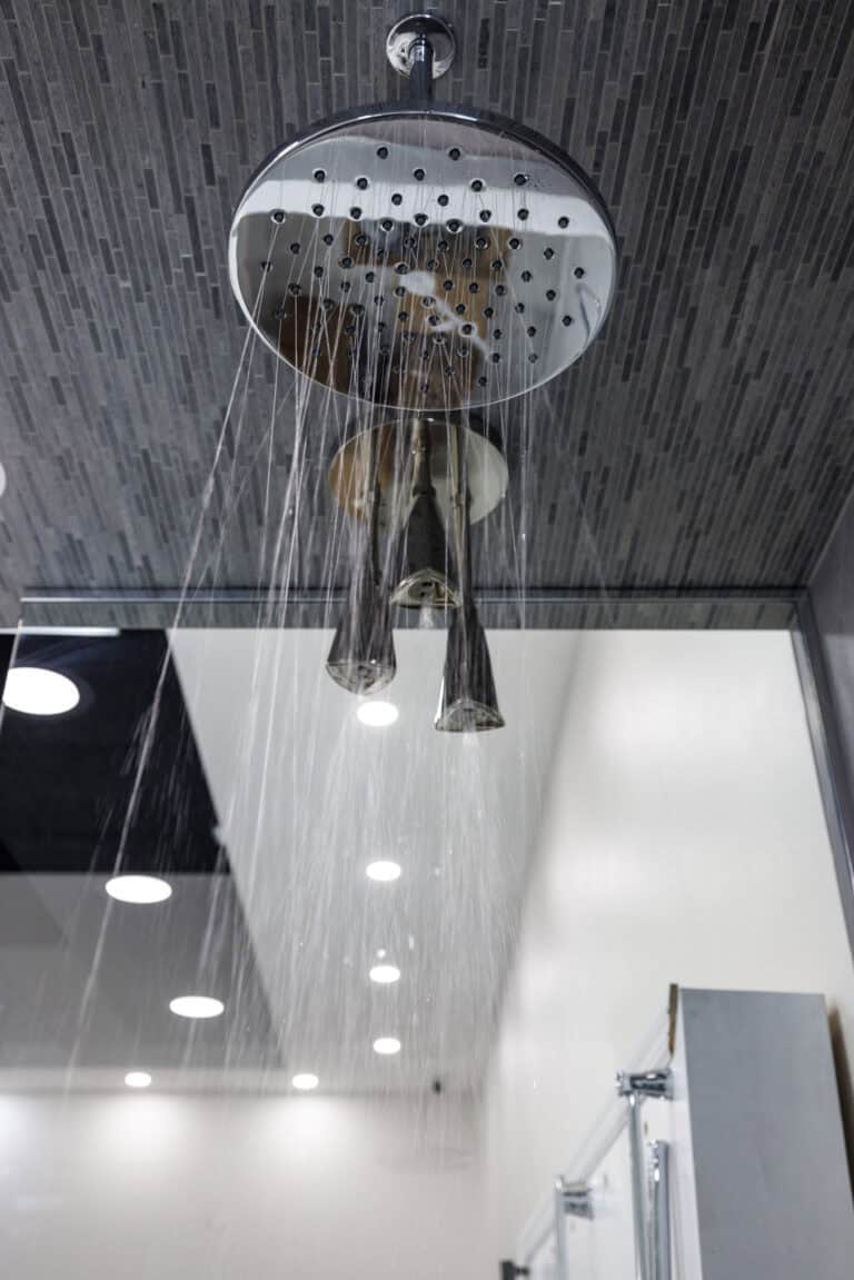 Modern showerhead with water spewing from its faucet.