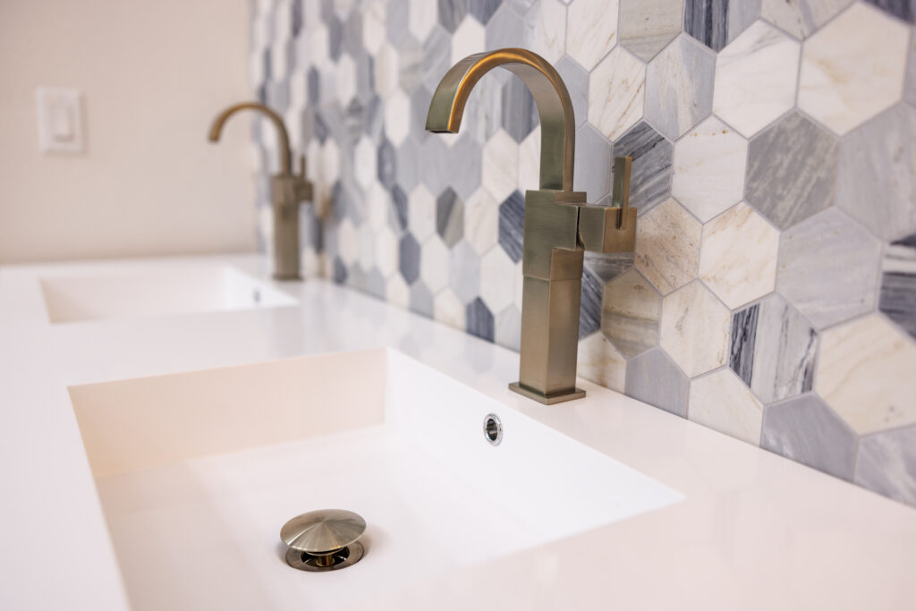 Modern bathroom sink with stylish faucets and tiles.