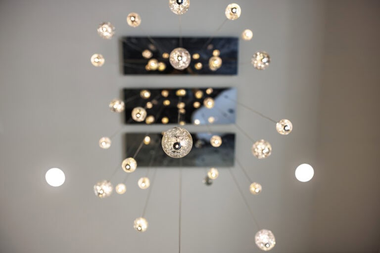 Multi-piece overhead lighting with dozens of small light fixtures.