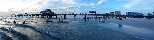 Panoramic view of a beach pier at sunset.