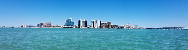 City skyline over calm blue water under clear sky