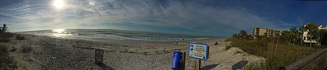 Panoramic view of a beach with sign