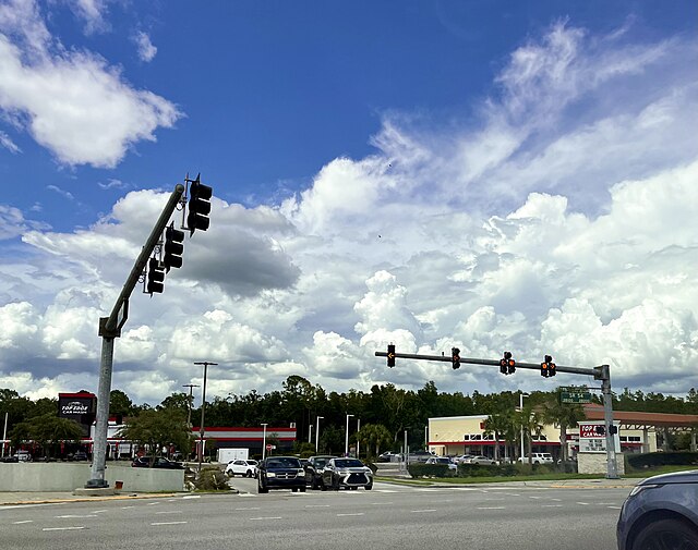 Traffic lights and clouds in a blue sky.