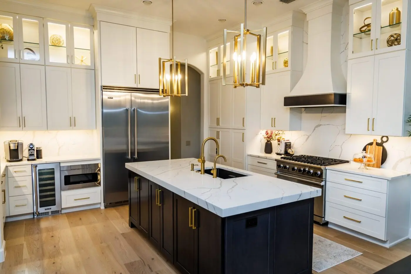 A completed Tampa kitchen project by CMK Construction with new white and navy custom cabinets, quartz counters, and gold hardware