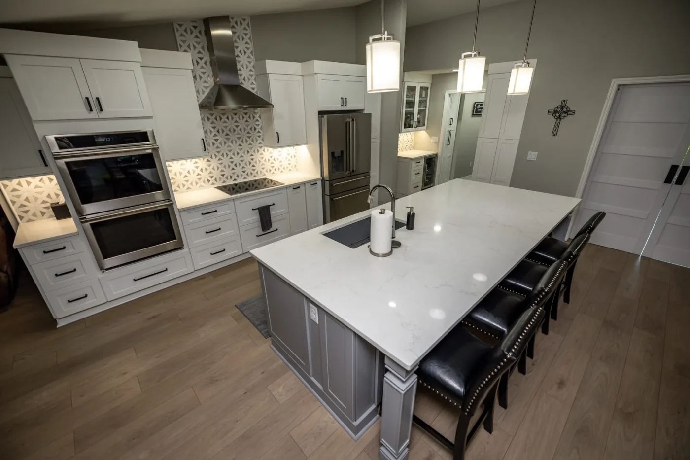 Gray kitchen island with Aspen White quartz countertop and leather stools seating five in a St. Petersburg kitchen remodel by CMK