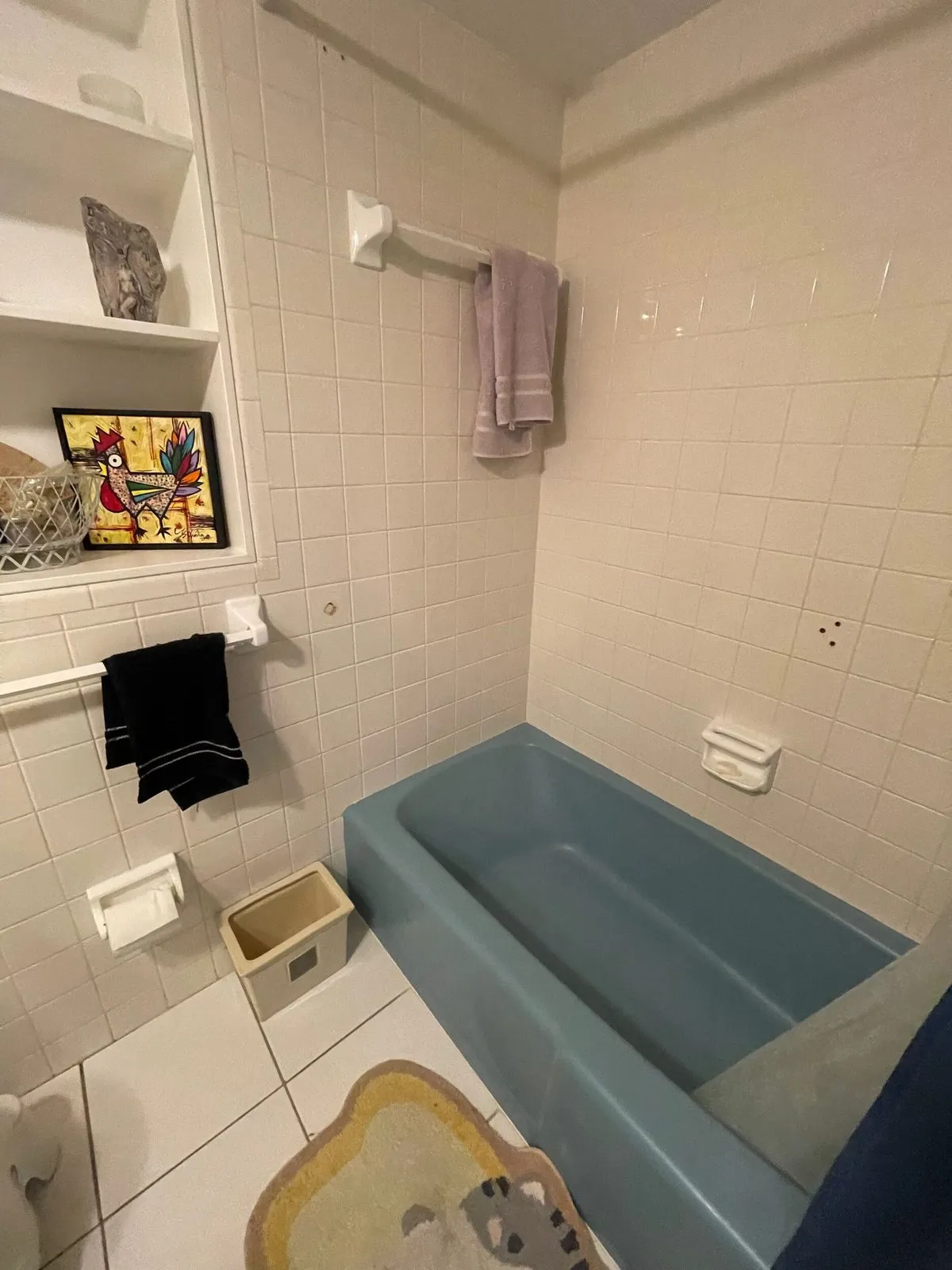 Bathroom before remodeling in Clearwater with original teal bathtub and dated square wall tile