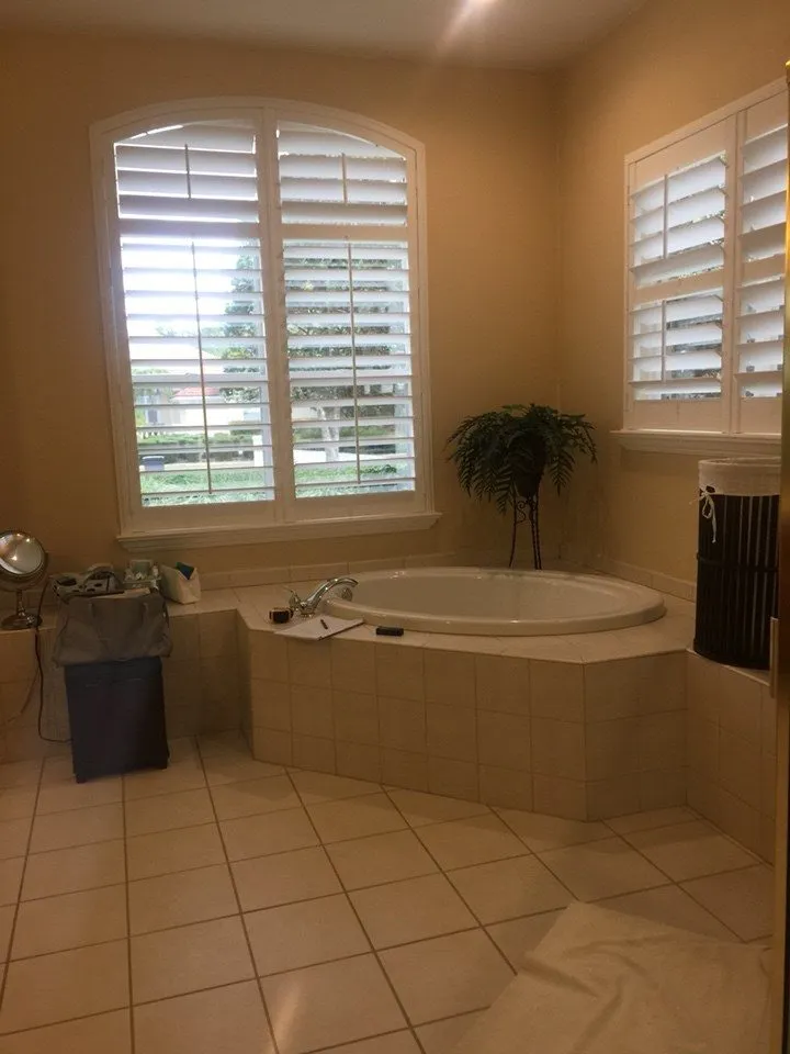 Corner drop in garden tub under an arched window before remodeling in a New Tampa primary bathroom