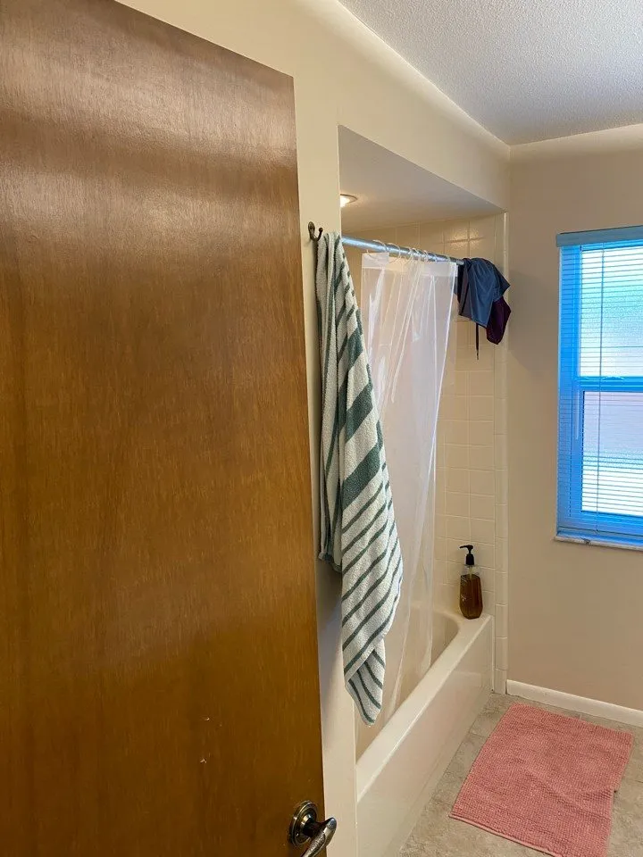 Tub and shower combo with plastic curtain before remodeling in a Siesta Key bathroom