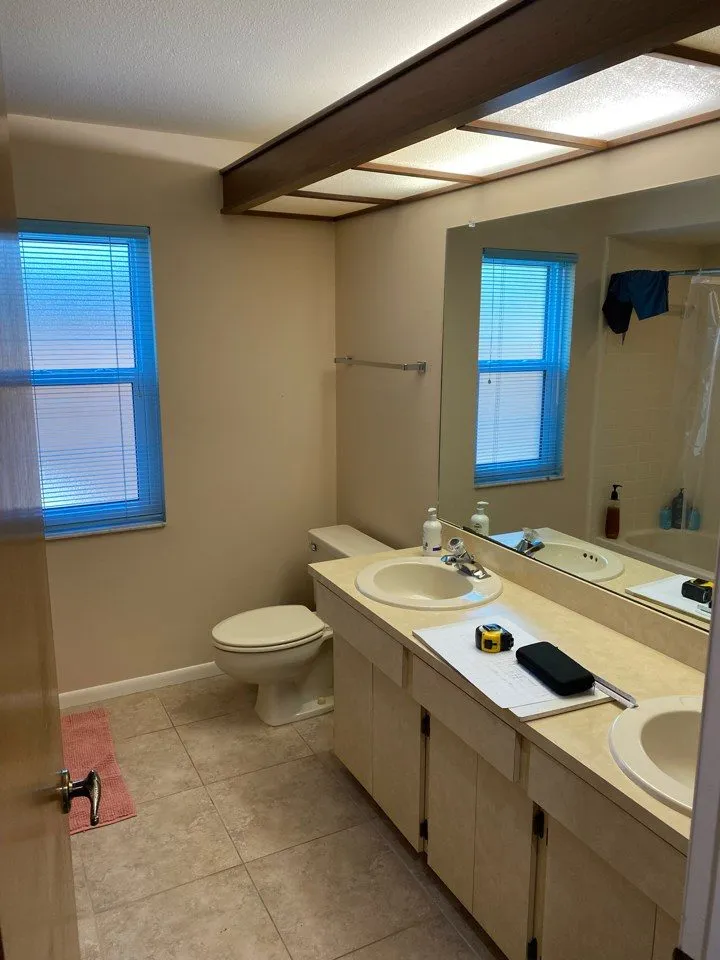 Beige cultured marble vanity and dated soffit lighting before remodeling in a Siesta Key bathroom