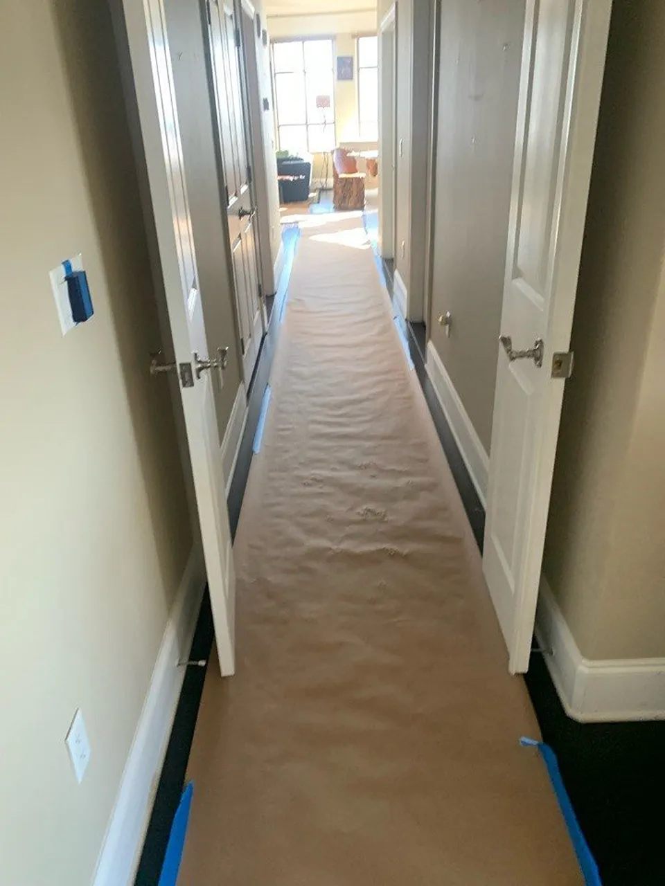 Madeira Beach bathroom remodel with floor paper taped through an occupied condo hallway from the entry to the work area.