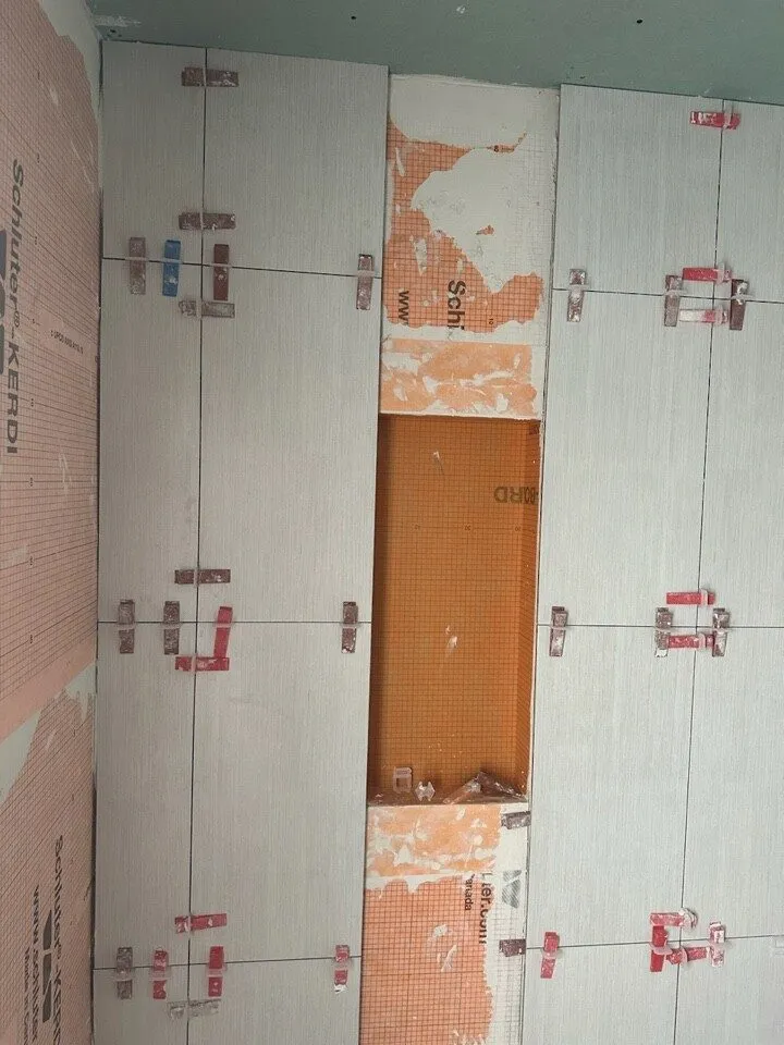 Large format tile installation with leveling clips during a Safety Harbor bathroom remodel by CMK Construction