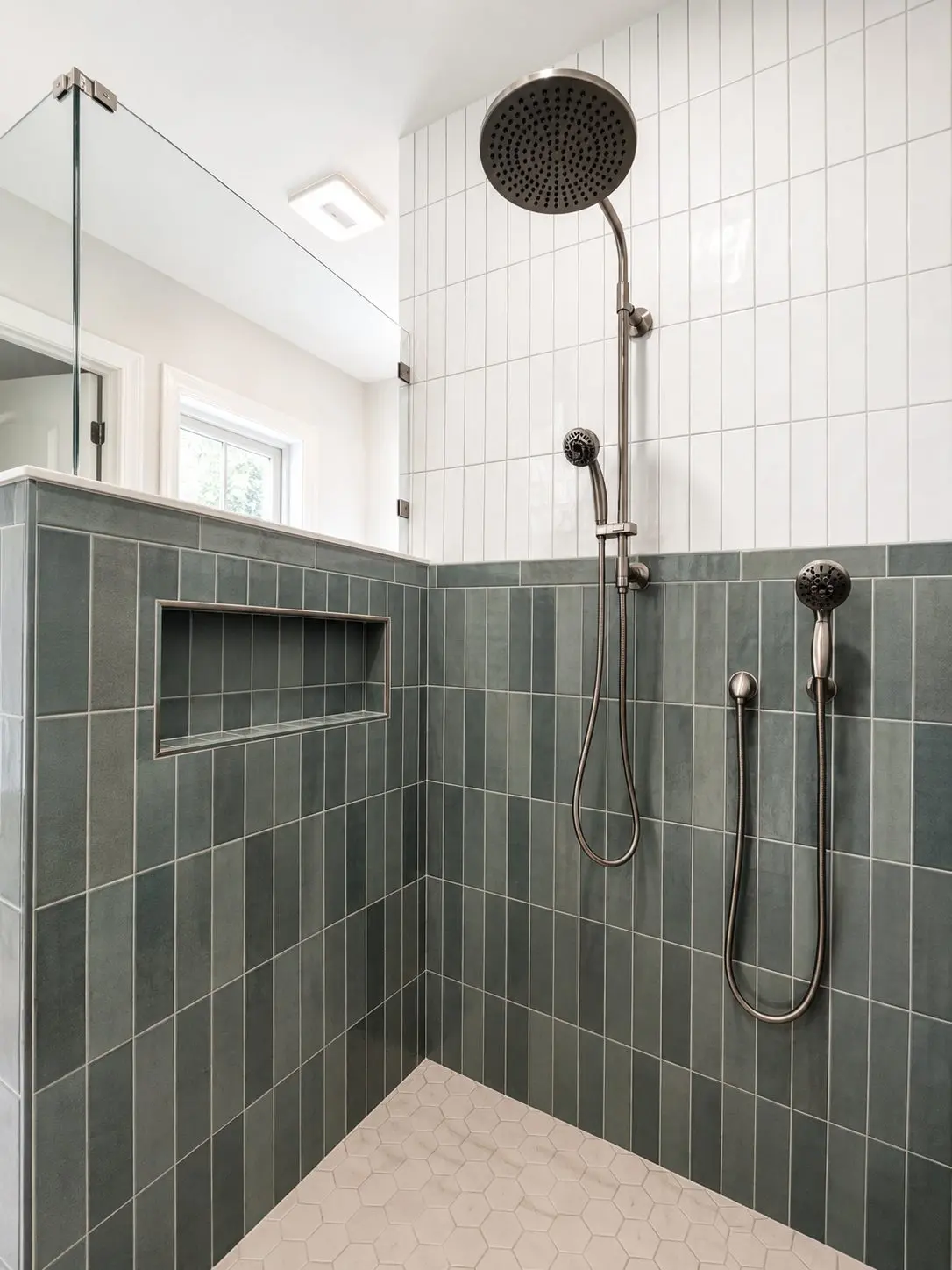 Shower with deep green vertically stacked tile below white vertically stacked tile and a hexagon mosaic floor in a Seminole master bathroom remodel