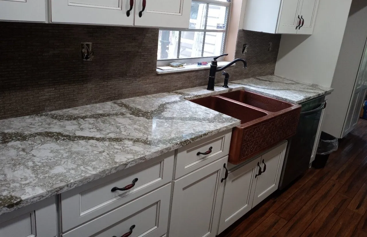 Cambria Beaumont quartz countertops with a hammered copper farmhouse sink and bronze faucet in a Tampa kitchen remodel
