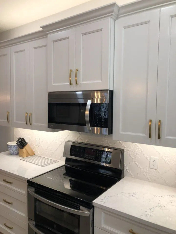 Cambria Portrush quartz countertops with white cabinets, gold hardware, and arabesque backsplash in a Trinity FL kitchen