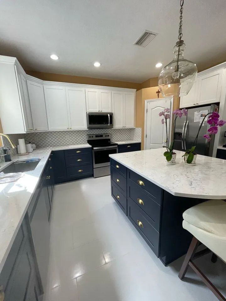 Navy blue kitchen island with Cambria Travella quartz countertop and brass cup pulls in a Lutz FL remodel by CMK
