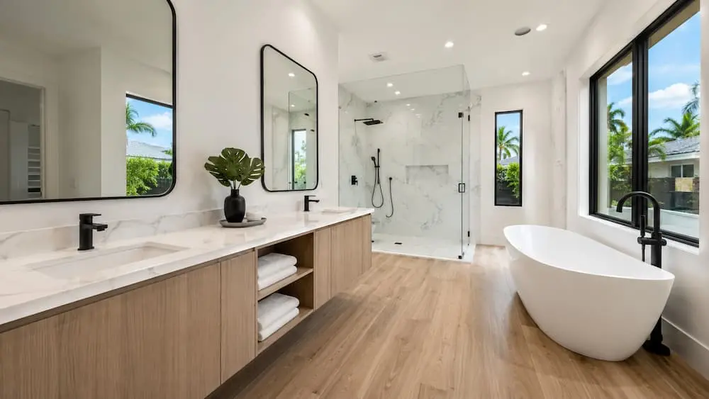 Primary bathroom remodel with a custom tiled walk-in shower, freestanding tub, and double vanity by CMK Construction