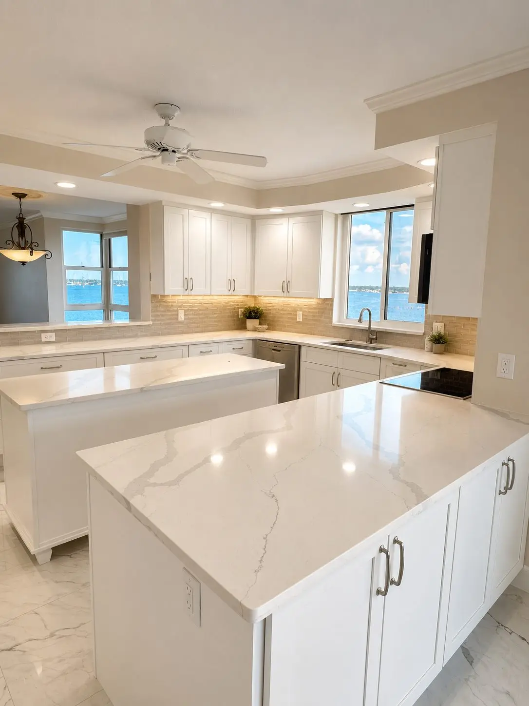 siesta key florida white kitchen detail view with veined quartz island and sand tone backsplash by cmk construction