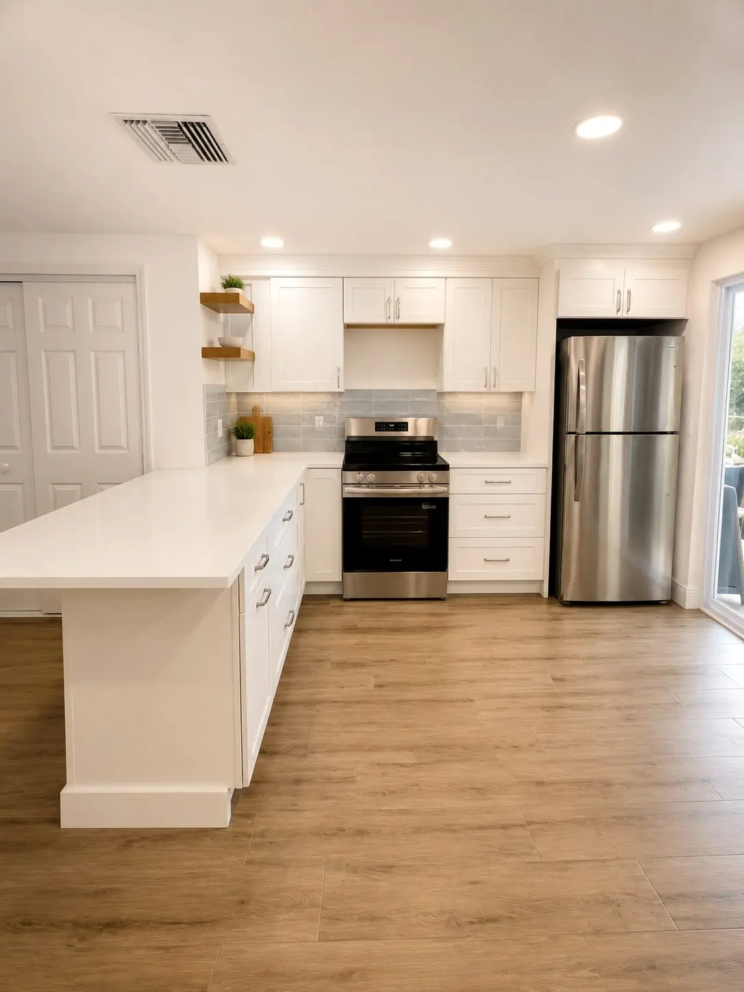 compact white kitchen with peninsula, pale blue backsplash, and floating shelves in lakewood ranch florida by cmk construction