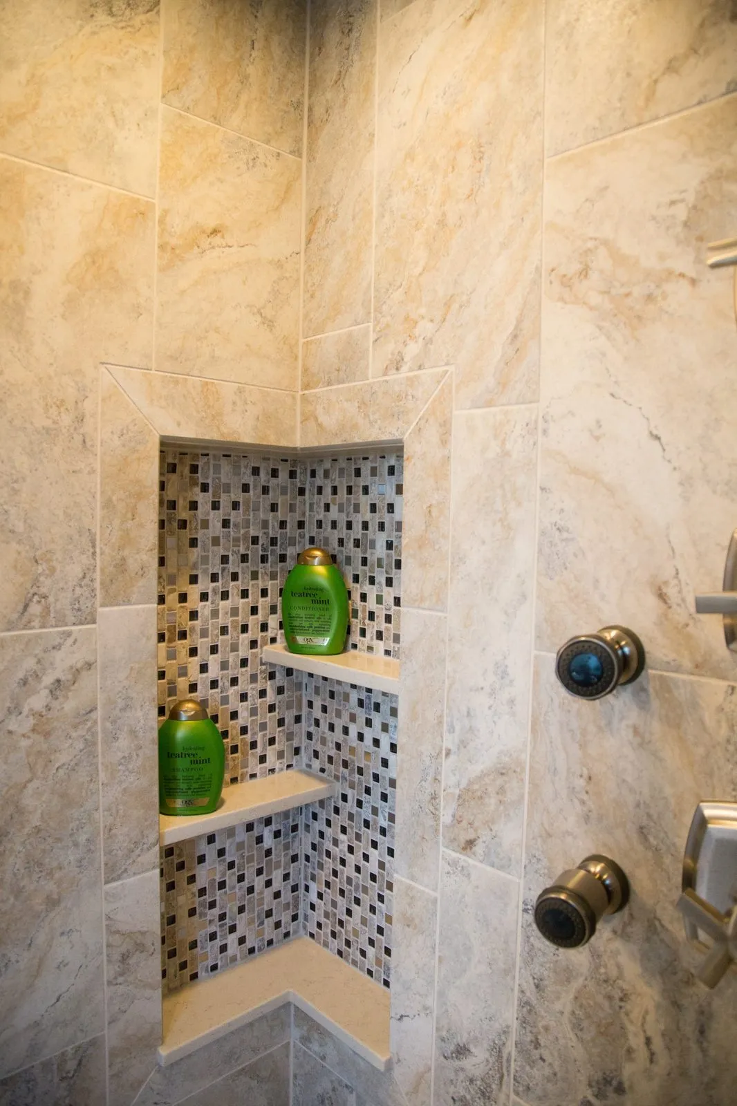 Recessed corner shower niche wrapping the inside corner with mosaic interior and solid stone shelves, Sarasota bathroom remodel by CMK