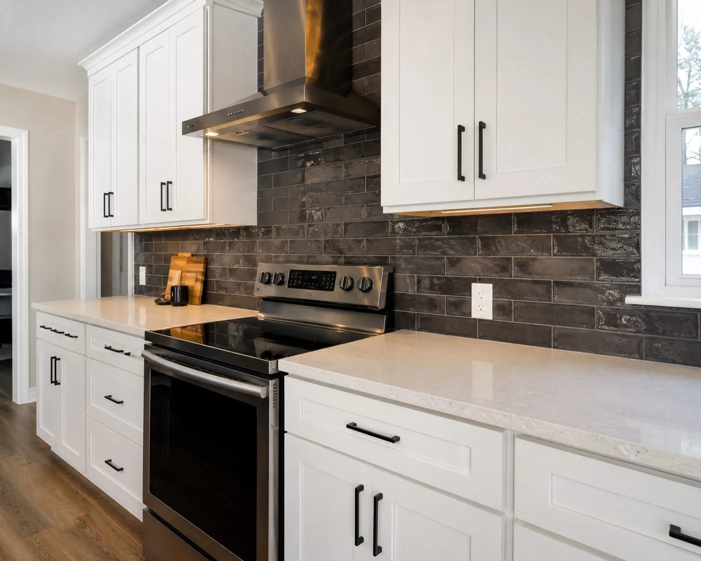 Glossy charcoal subway tile backsplash contrasting with white shaker cabinets in a Brandon kitchen remodel by CMK Construction