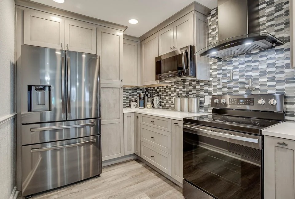 Palm Harbor Florida condo kitchen with Fabuwood Fusion cabinets in a light greige stain, mosaic tile backsplash, and stainless appliances by CMK Construction