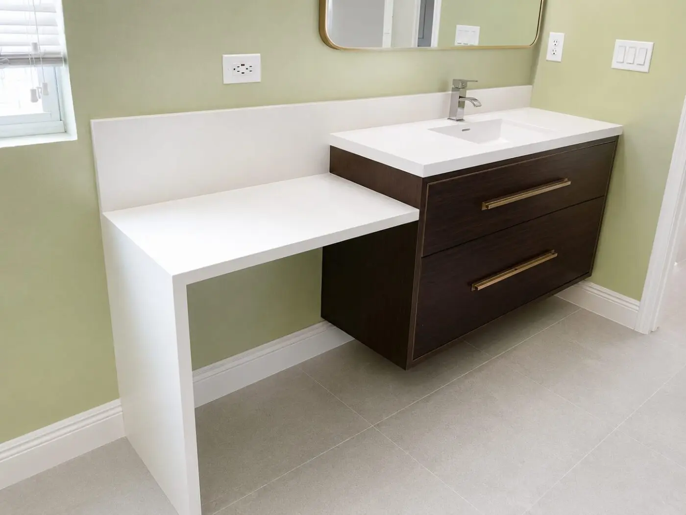 Floating walnut vanity with attached seated makeup counter and white countertop in a Tampa bathroom remodel
