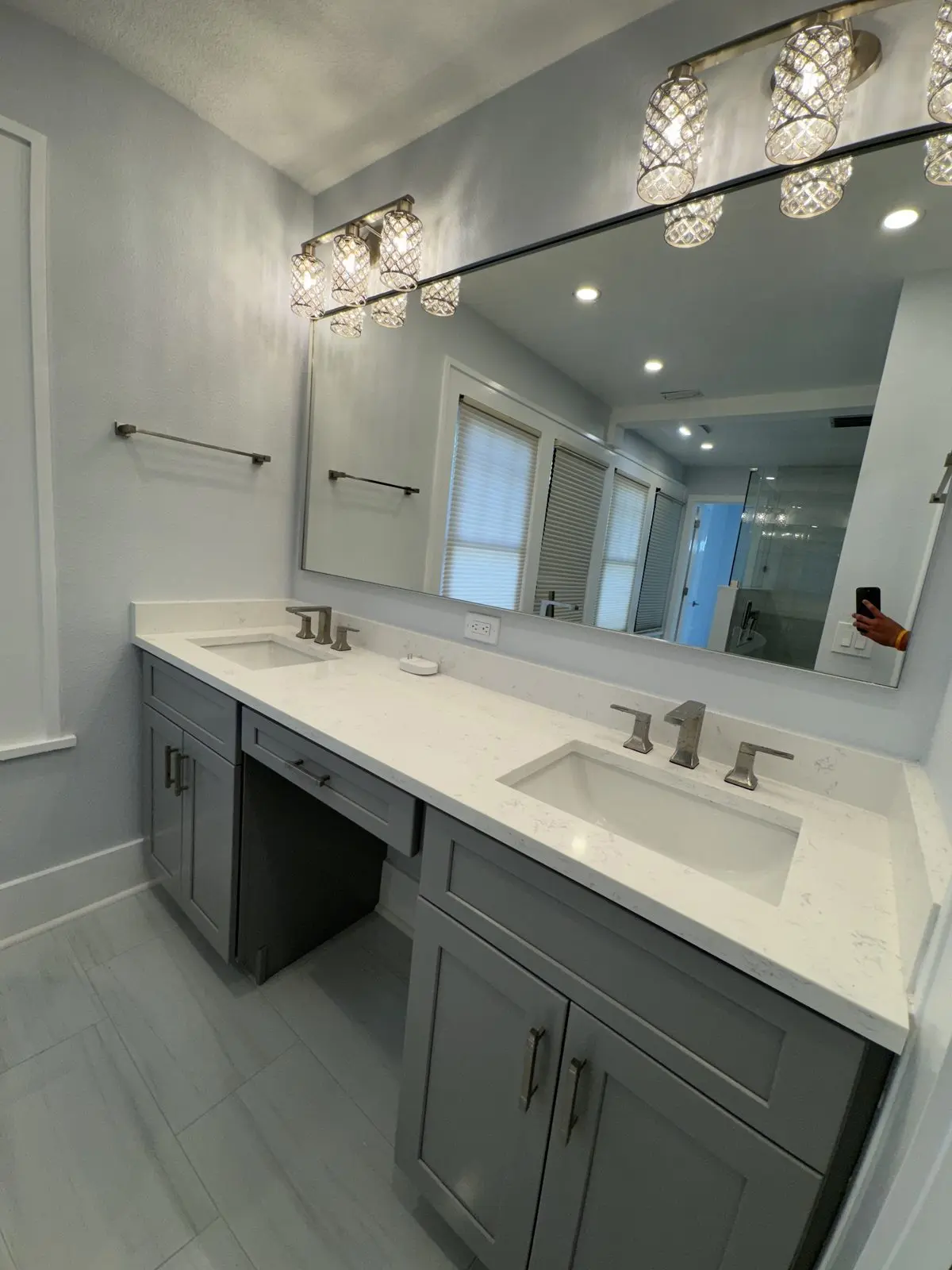 Gray double vanity with quartz countertop and lowered makeup section in a Tampa bathroom remodel