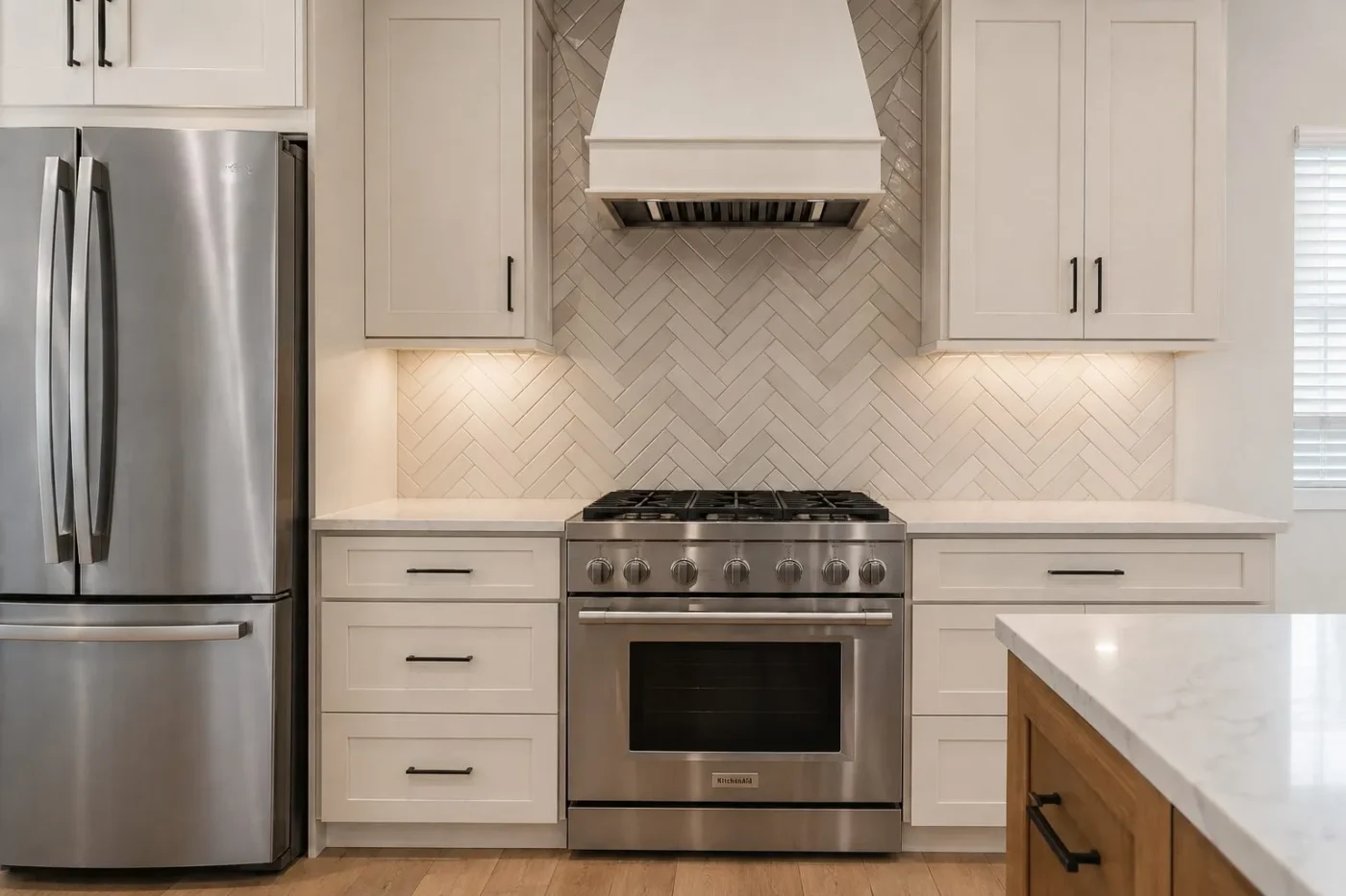 Two tone herringbone tile backsplash running to the ceiling behind the range in a Lutz kitchen remodel by CMK Construction