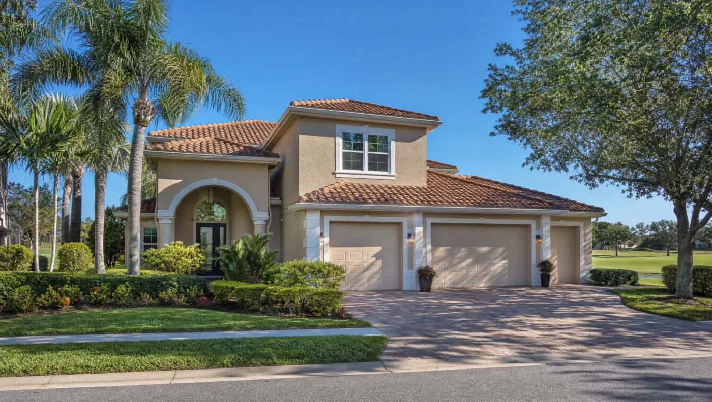 Two-story Mediterranean-style stucco home with a barrel tile roof and three-car garage in a Lakewood Ranch golf course community