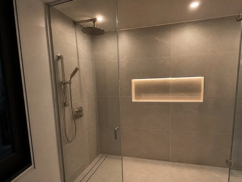 Walk-in shower lighting idea with wet-rated recessed LEDs and a lighted tile niche, a popular upgrade for Wesley Chapel remodels