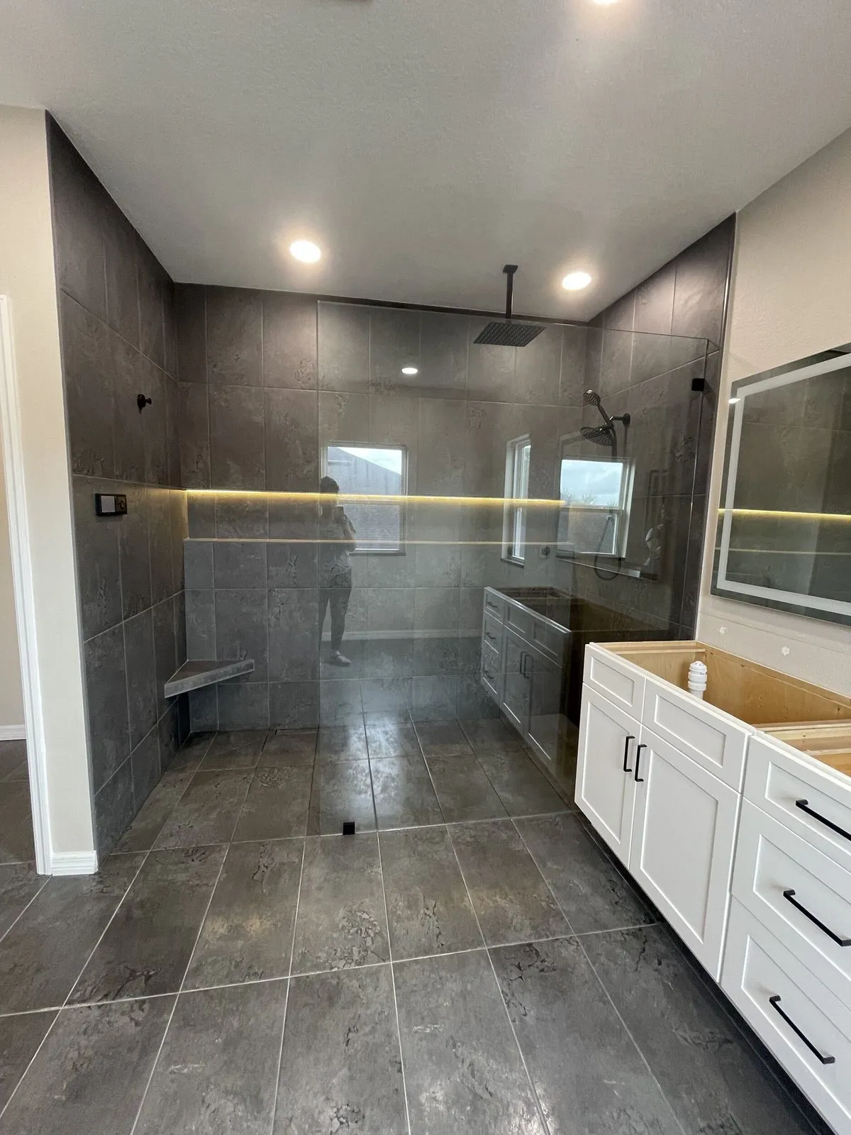 LED lit full width shower niche glowing across the back wall of a South Tampa shower remodel by CMK