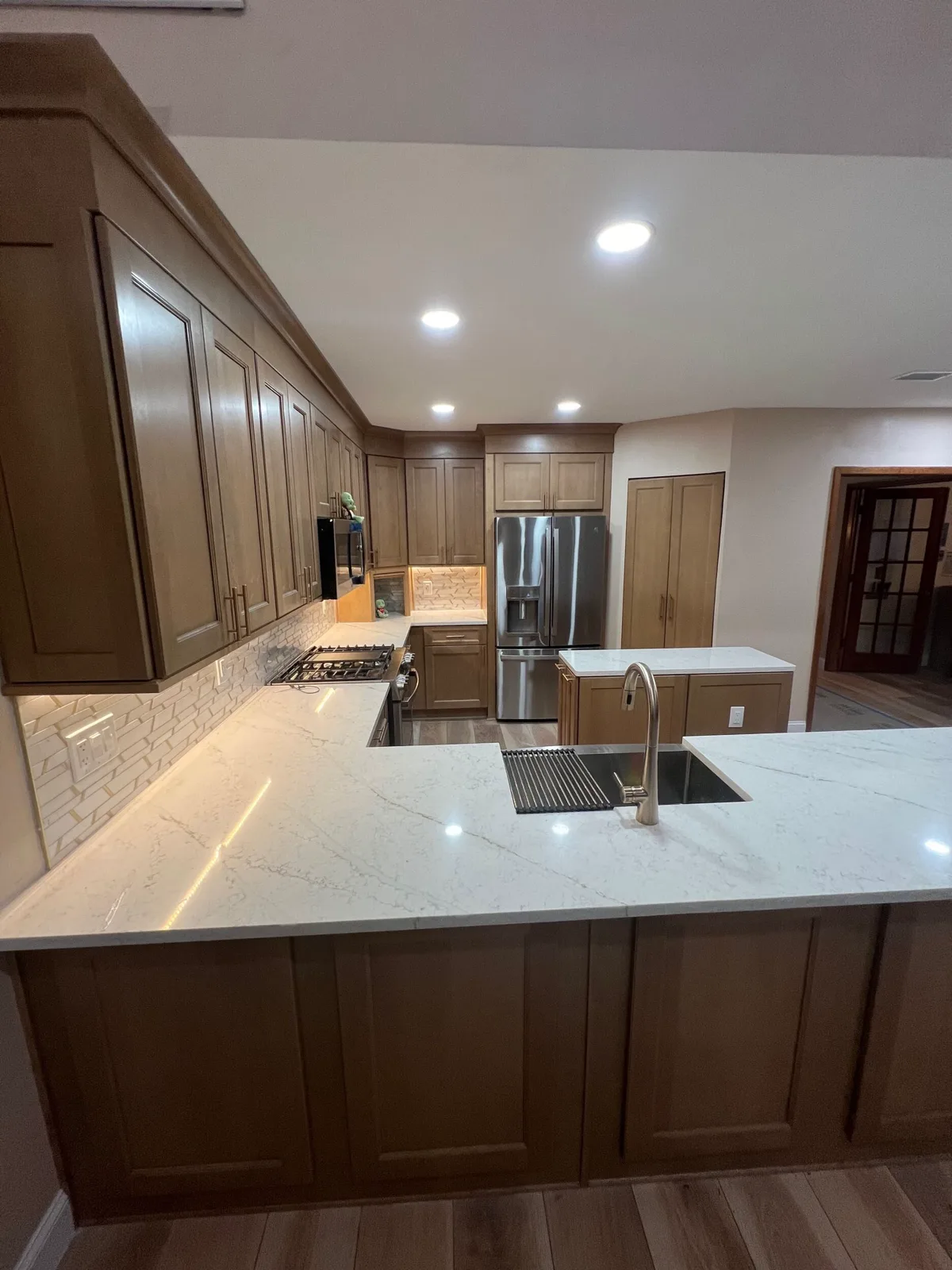 Finished Odessa kitchen looking across the quartz peninsula toward the great room