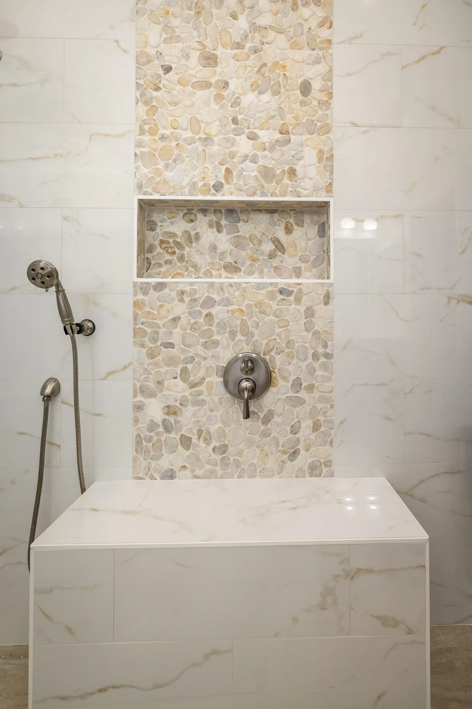 Pebble stone accent column with shower niche in Siesta Key FL