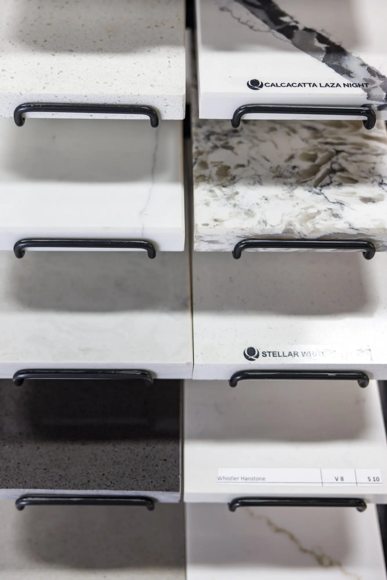 Quartz countertop slab samples at the CMK Design Studio in Tampa, including Calacatta and Stellar White patterns