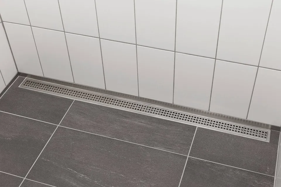 Schluter KERDI-LINE linear drain installed flush with large-format tile in a modern curbless shower