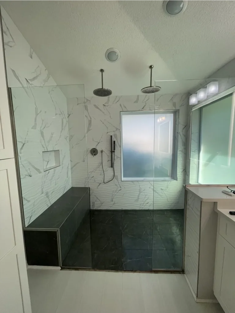 Contemporary bathroom featuring a dark double vanity, a large mirror, and a walk-in shower.