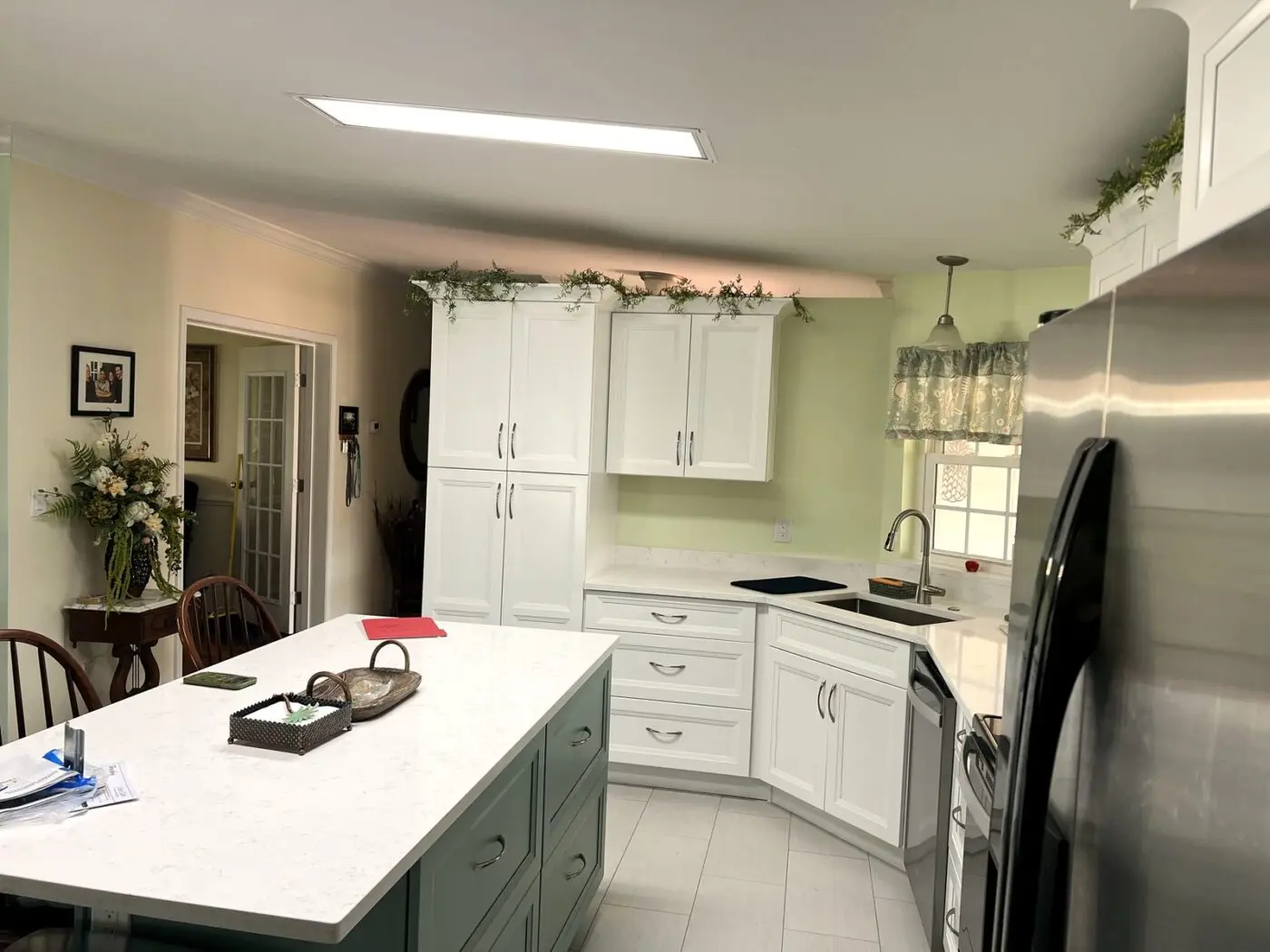 two tone kitchen idea with white perimeter cabinets and sage green island in a St Pete Beach Florida remodel by CMK Construction